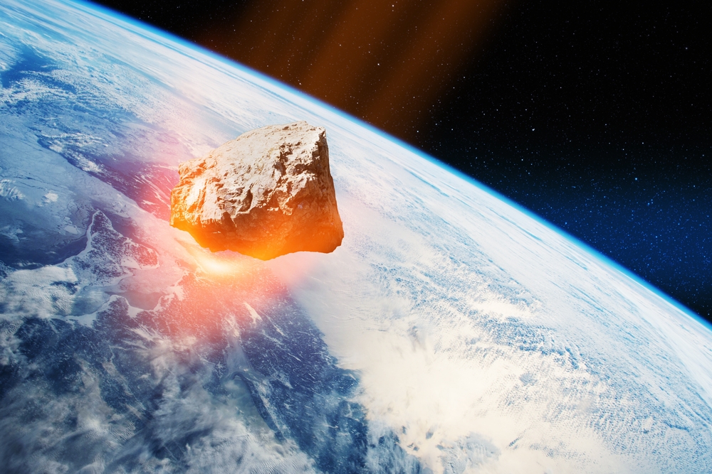 An asteroid in space with the planet earth in the background