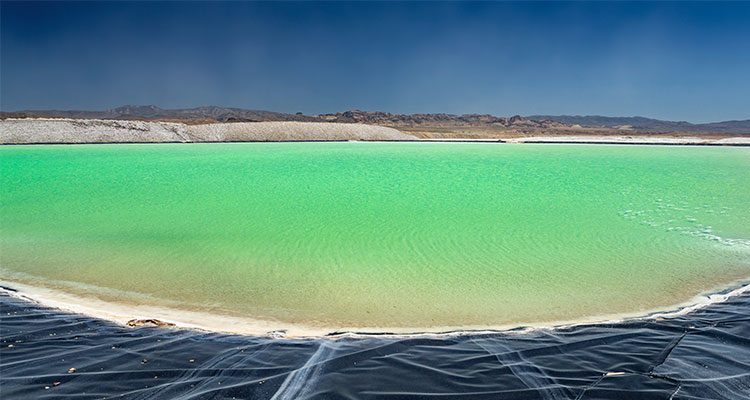 An evaporation pool at a lithium mine beneath a blue sky