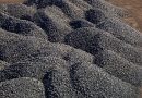 Piles of manganese ore are resting on the ground.