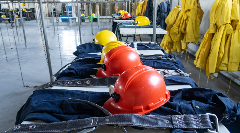 Mining equipment including hats and work clothes lined up in room to support Agnico Eagle article