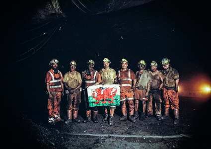 miners at the Aberpergwm Anthracite Mine in South Wales, holding the flag of Wales