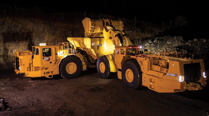 CAT underground mining equipment operating in a mine with a loader transferring material.